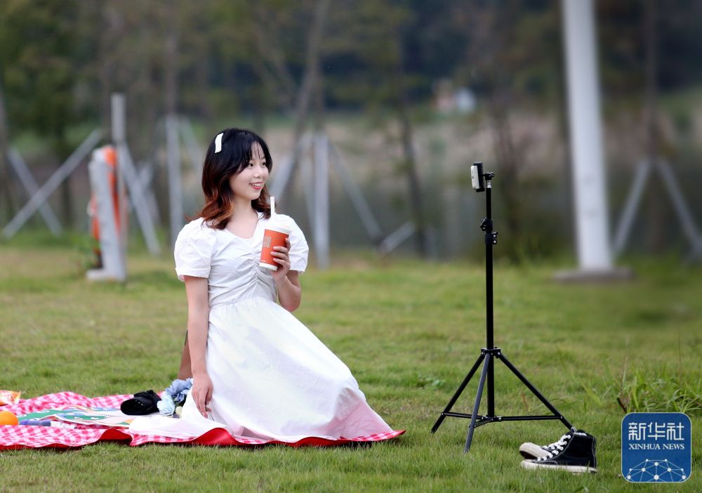 11月21日，在广东省西瓜视频
鹤山公园，一名游人身着裙装自拍。.jpg